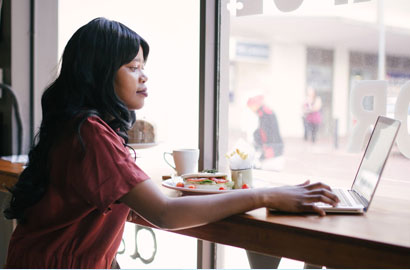 Focused Woman Working on Laptop in a Café